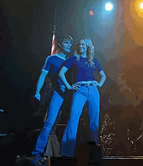 a man and a woman are dancing on a stage in front of an american flag