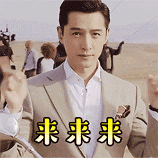 a man in a suit and white shirt is standing in front of a group of people with chinese writing on them .