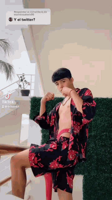 a shirtless man in a kimono is sitting on a red stool .