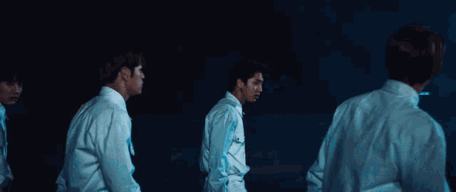 a man in a white shirt is standing in the dark