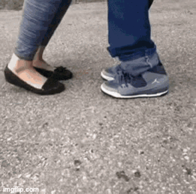 a man and a woman are standing next to each other on the street .