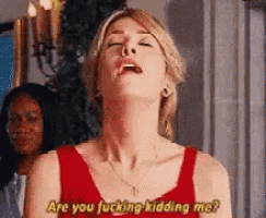 a woman in a red dress is making a funny face and says `` are you fucking kidding me ? ''