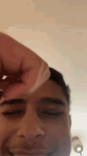 a close up of a person 's face with their hand on it