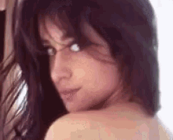 a close up of a woman 's face and shoulder .