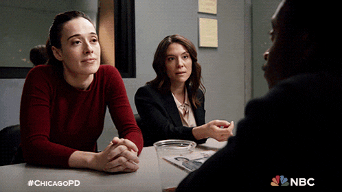 two women sit at a table talking to a man with #chicagopd written in the corner