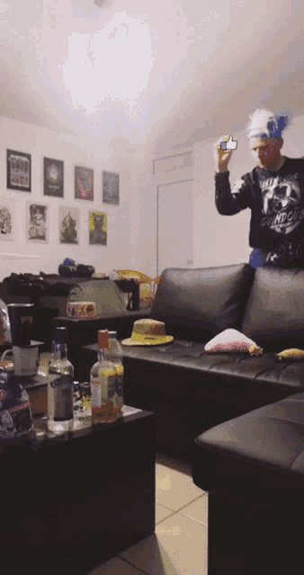 a man is taking a picture of himself in a living room while wearing a blue and white headpiece
