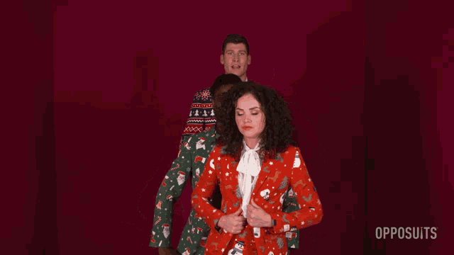 a woman in a red suit is dancing with two men in opposuits suits
