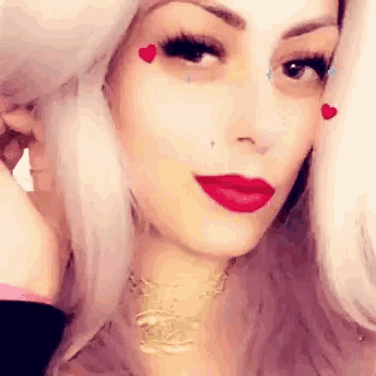 a close up of a woman 's face with red lipstick and hearts on her face .