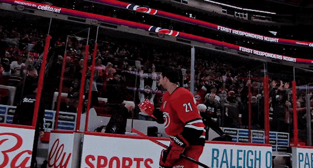 a hockey player wearing number 21 stands in front of a crowd