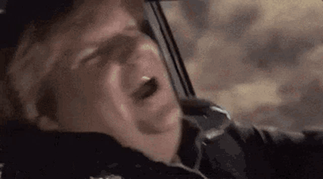 a man is crying while driving a car .