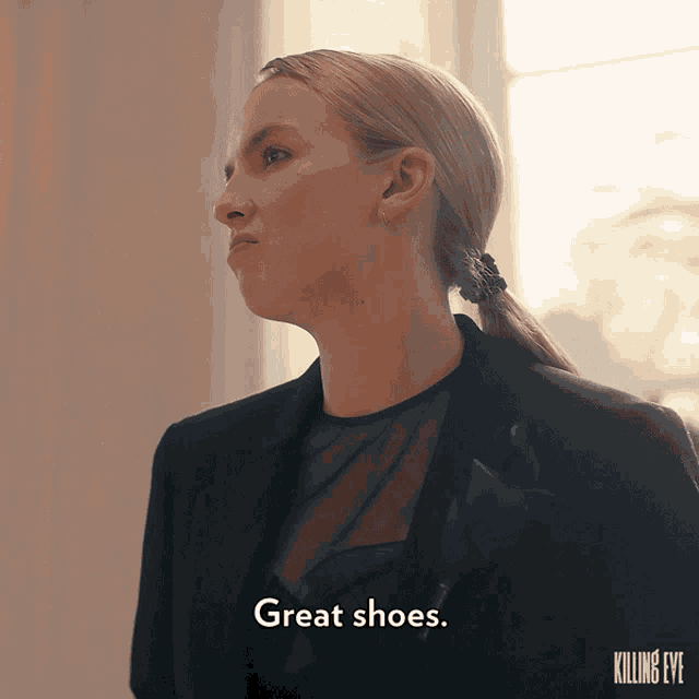 a woman wearing a black jacket and a black top says great shoes