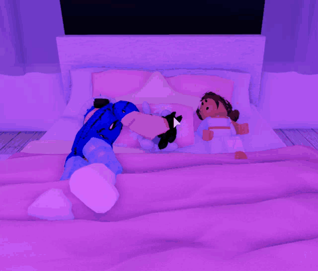 two dolls are laying on a bed with purple sheets and pillows