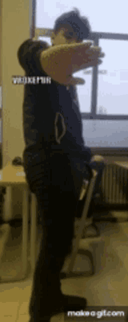a man is standing in front of a window with his arms outstretched in a room ..