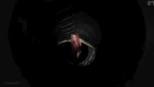 a woman with red hair is wearing a black top