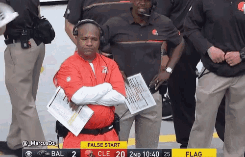 a man in a red jacket is sitting in front of a scoreboard that says " false start "