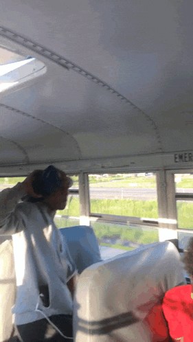 a man sitting on a bus with a sign that says emergency