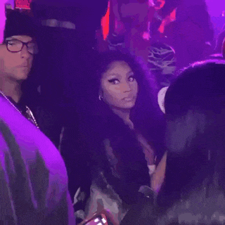 a man and a woman are standing in a crowd of people at a concert .