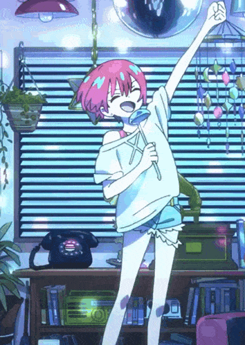 a girl with pink hair is singing into a microphone in a room