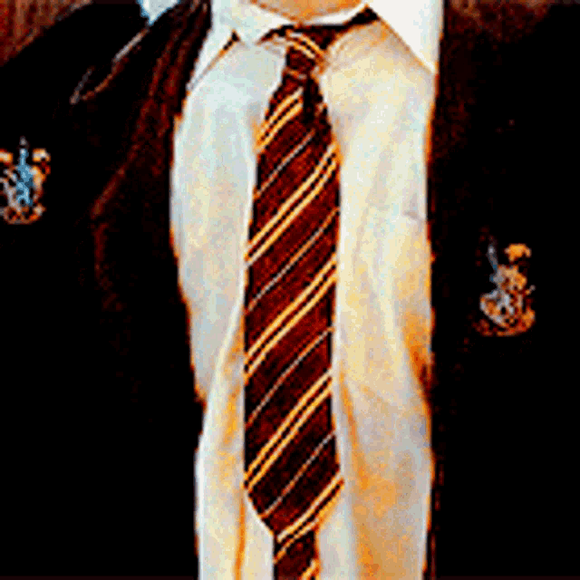 a man wearing a striped tie and a coat with a crest on it
