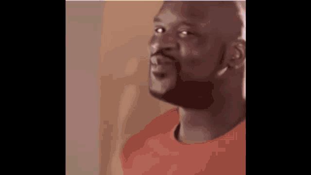 a close up of a man with a beard wearing a red shirt and looking up .
