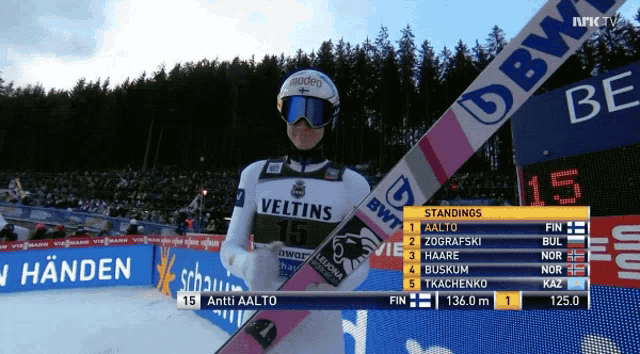 a man in a veltins jersey holds a ski