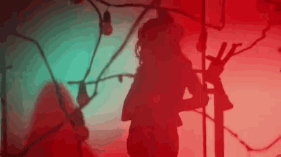 a silhouette of a woman standing in front of a red and blue background .