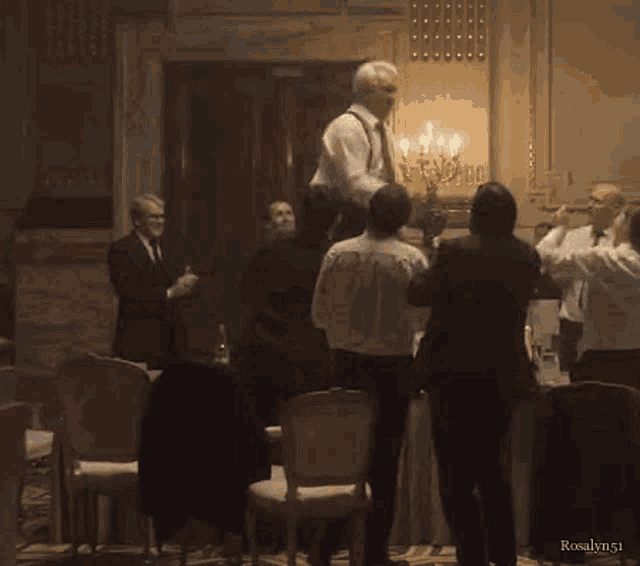 a group of men are gathered around a table with the name rosalyn51 on the bottom