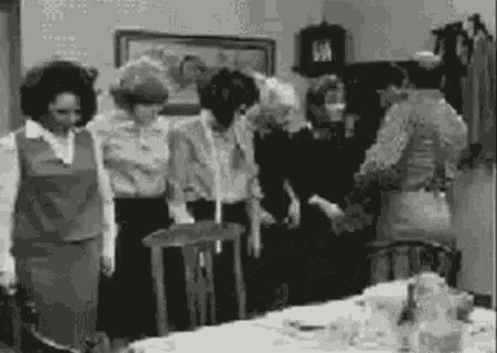a group of people are standing around a table .