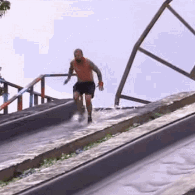 a man without a shirt is running down a concrete ramp .