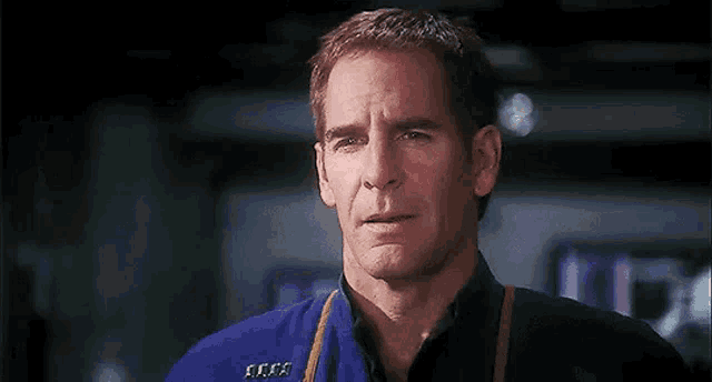 a man in a blue shirt is crying with his eyes closed .