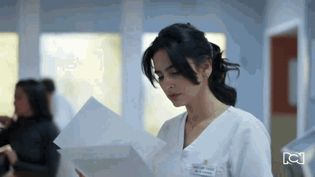 a woman in a white scrub has a name tag that says ' juan carlos ' on it