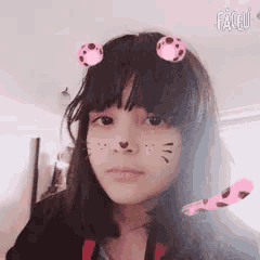 a girl with a cat face painted on her face and faceu written in the corner