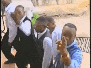 a group of men in suits and ties are standing in a line .