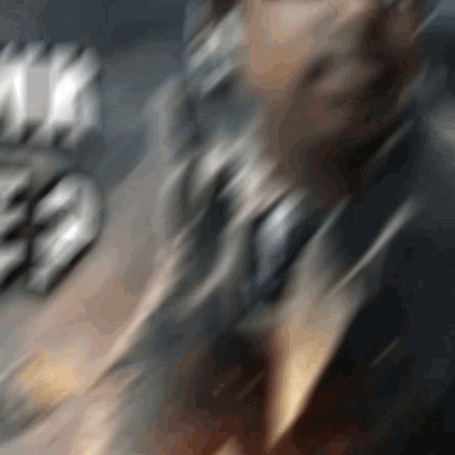 a blurry picture of a man 's face with a few letters in the background that says ' a '