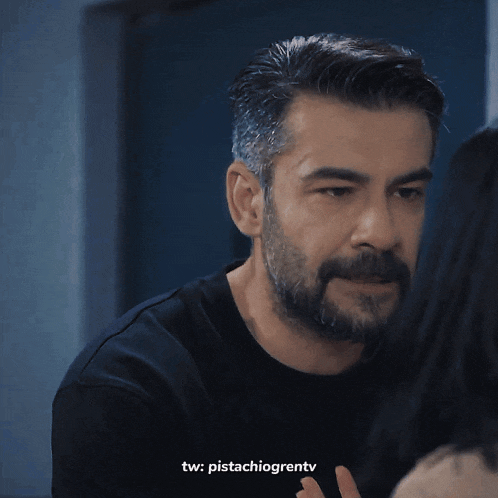 a man with a beard is looking at a woman with the words tw : pistachiogrentv on the bottom
