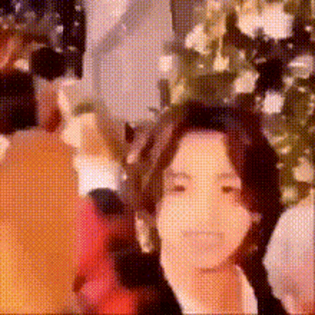 a blurry picture of a woman standing in front of a christmas tree