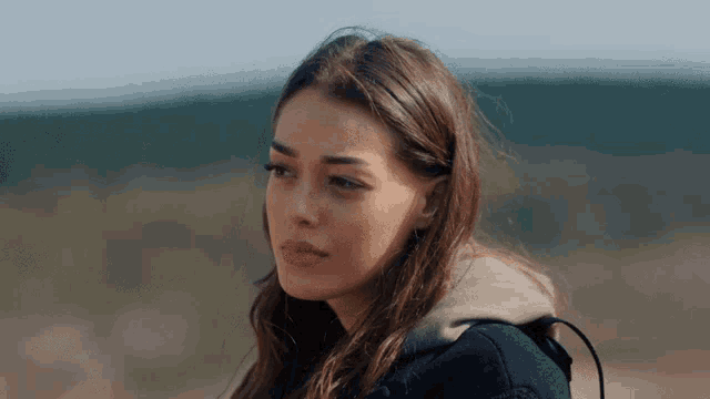 a close up of a woman 's face with a hoodie on