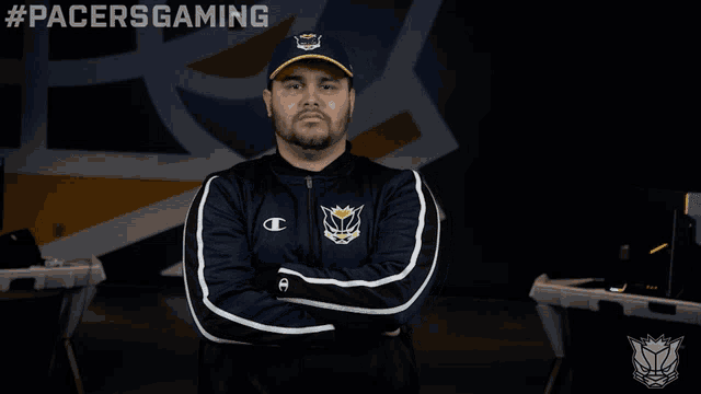 a man with his arms crossed wears a champion jacket