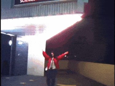 a woman in a red jacket is standing in front of a science sign