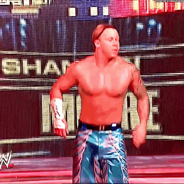 a wrestler is standing in front of a sign that says share