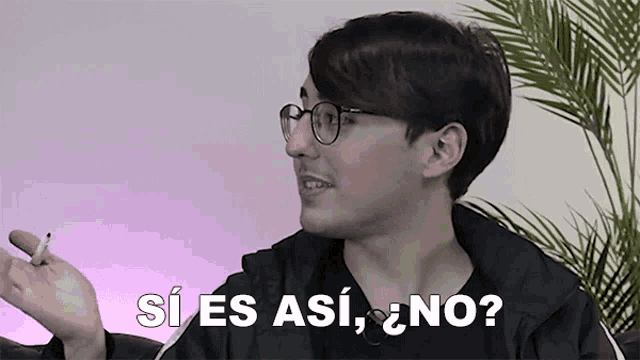 a man wearing glasses is holding a cigarette in his hand and says si es asi no ?