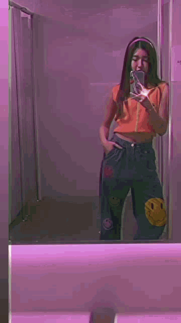 a woman is taking a selfie in a bathroom mirror