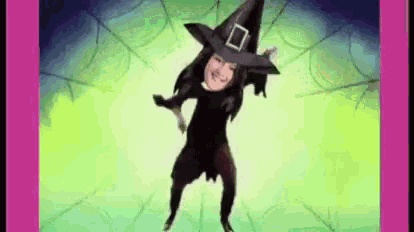 a woman in a witch costume is dancing in a green room .