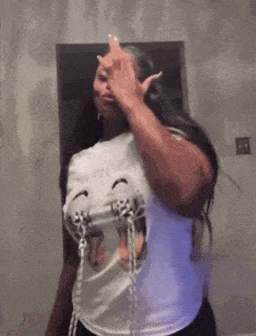 a woman in a white shirt is giving the middle finger