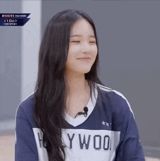 a girl with long hair is wearing a hollywood shirt and smiling with her eyes closed .