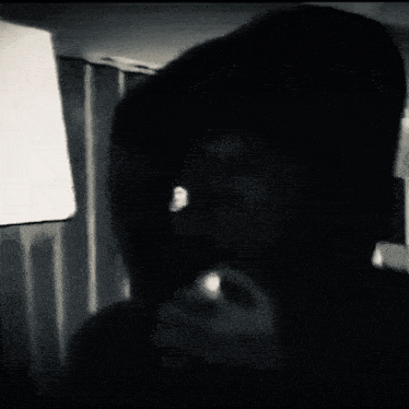 a black and white photo of a man in a hood