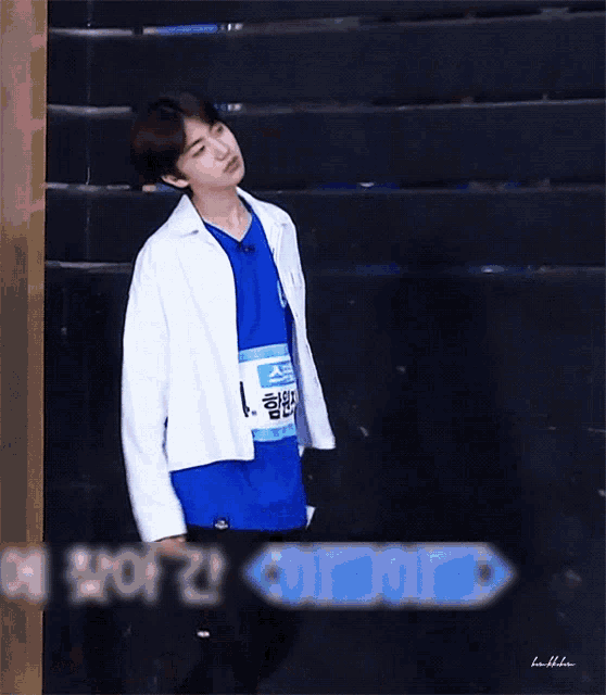 a young man wearing a blue shirt and a white jacket with the number 1 on his chest