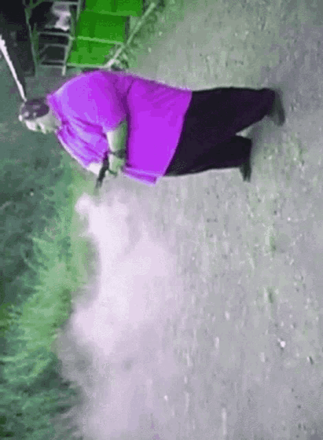 a man in a purple shirt is holding a gun and smoking a cigarette