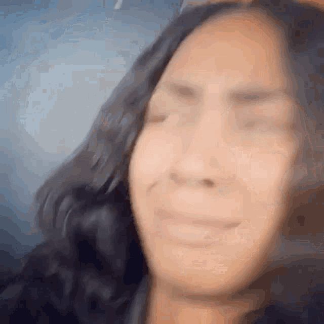 a close up of a woman 's face with her eyes closed and a smile on her face .