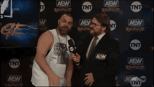 two men in front of a wall that says aew wrestling